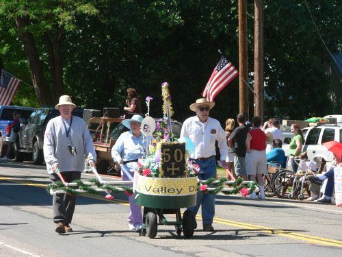 A 3 person (joke) wheelbarrow with seniors pushing it.