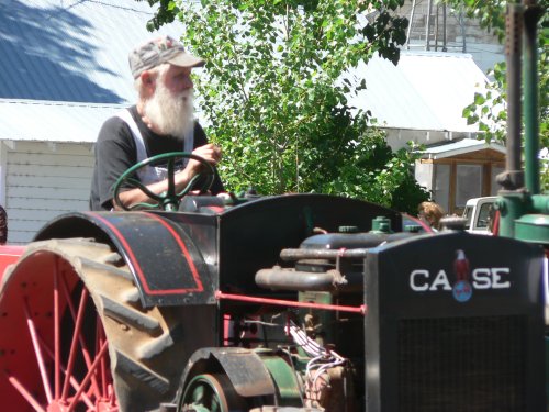 Willie Shepard with white beard on an old red tractor.
