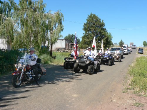 Modoc County Sheriff on motorcycle followed by pose on all terrain vehicles.