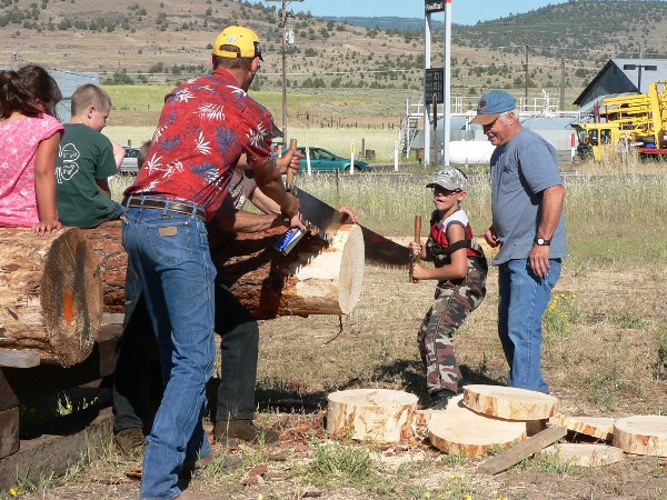 Father and son with big log and big saw