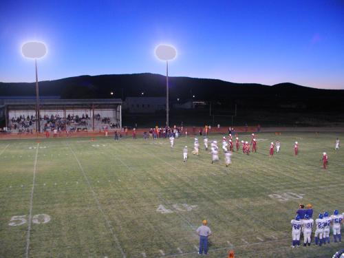 The football field, taken from a high obsewrvation point, with the sun sett over the distant mountains.