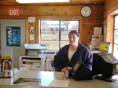 Katie standing behind her public Post Office Counter.