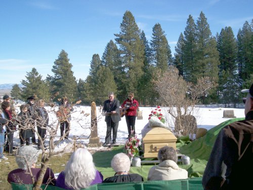 Erma's casket with Rev Jeff Bidwell reading. Snow in background.