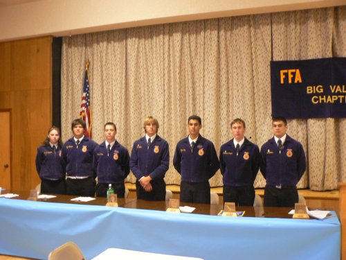FFA youngsters in Blue uniform standing behind the meeting table.