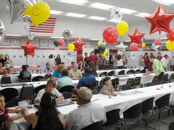 Balloons decorate a room with tables for a festive meal.