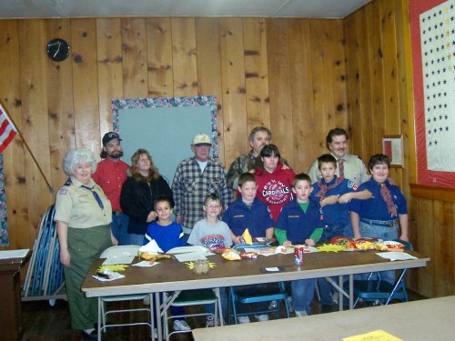 Cub Scouts with sponsors posed at meeting hall.