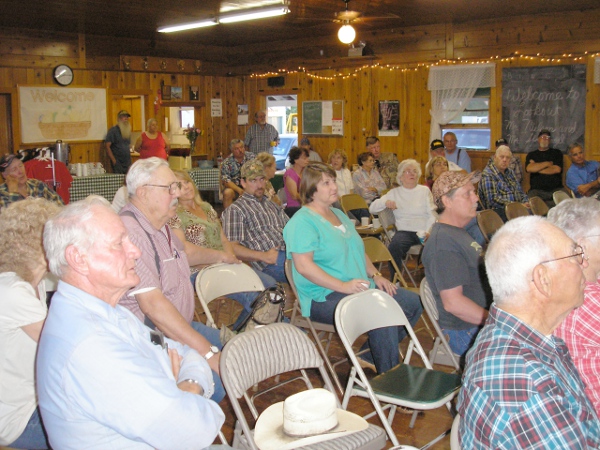 A crowd of 44 sits at a townhall meet.