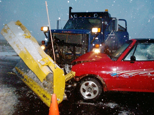A red car with minor damage that hit the front of a snow plow